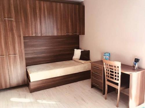 a small bedroom with a bed and a desk at FeEl Tatras Direct View apartment in Veľká Lomnica