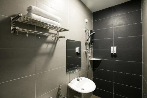 a bathroom with a sink and a toilet and a mirror at Canning 33 in Ipoh