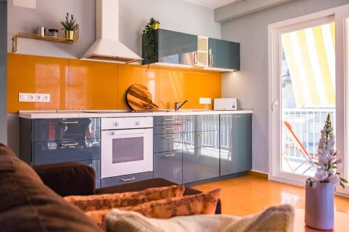 cocina con armarios de color naranja y horno en Apartamento Coral, en Denia