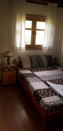 a bedroom with a large bed with a window at Mechta Guest House in Koprivshtitsa