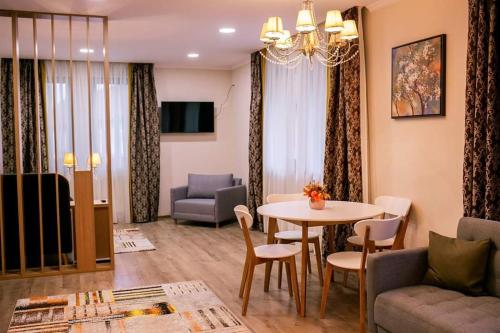 Sîngeorgiu de PădureにあるCasa Claudiaのソファとテーブルと椅子のあるリビングルーム