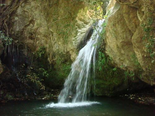 a waterfall in the middle of a pool of water at Guesthouse Amanitis Caesarea in Skíti