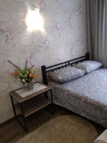 a bedroom with two beds and a table with flowers at Студия в Центре СКАЛА in Khmelnytskyi
