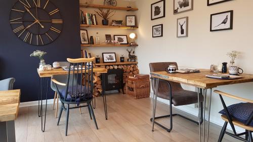 a room with two tables and a clock on the wall at Airanloch, Loch Ness, Adult Only in Lochend