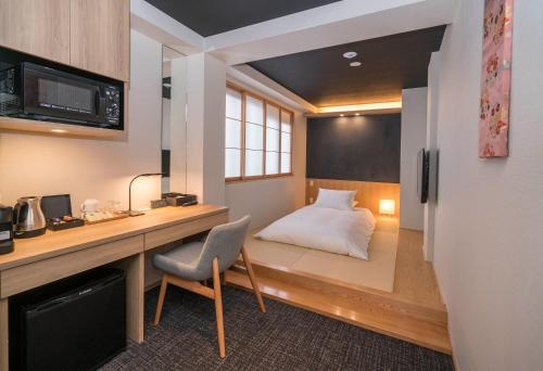 京都市にあるMiru Kyoto Nishikiのベッド、デスク、椅子が備わる客室です。