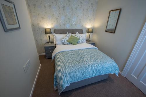 a bedroom with a bed with a blue blanket at Ninety Seven in Holywood