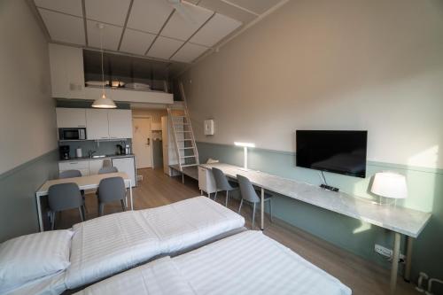 a room with two beds and a table with chairs at Innotelli Apartments in Helsinki