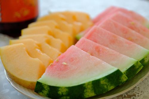 un plato de melones y rodajas de sandía sobre una mesa en Seva Vegetarian Guesthouse in Byurakan, en Byurakan