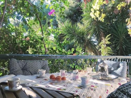 a table with a plate of fruit and coffee cups at A1 Elegant Vouliagmeni apt in a Unique Spot in Athens