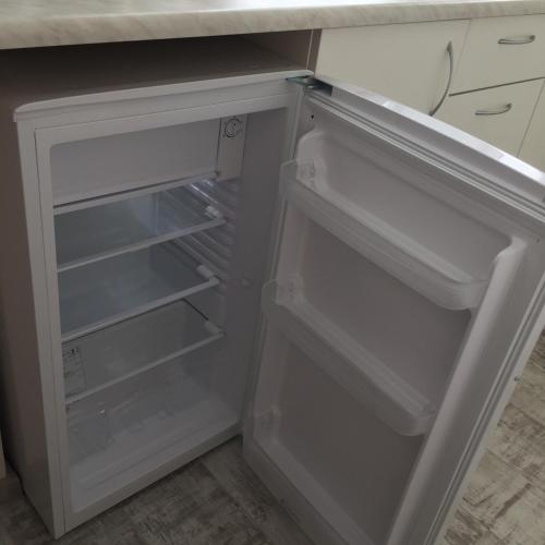 an empty refrigerator with its door open in a kitchen at Cat Garden Deluxe Apartments Riga in Rīga