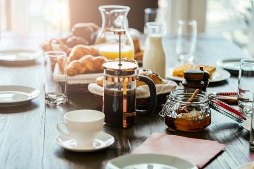 a wooden table with food and coffee on it at Boutique-Hotel Anno 1910 in Wernigerode