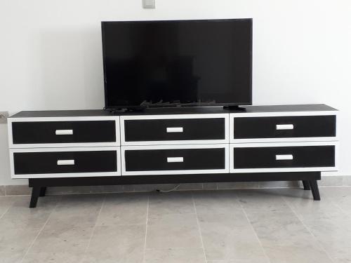 a black and white dresser with a flat screen tv on it at Maison des Oliviers, Yasmine Hammamet, Bouficha in Hammamet Sud