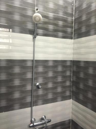 a shower in a bathroom with black and white stripes at Ahi House in Kilinochchi