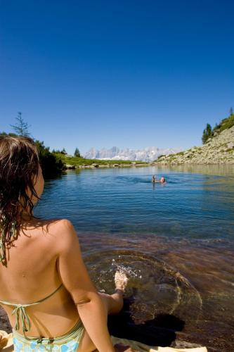 a woman in a bikini standing in the water at Haus Alexander in Schladming