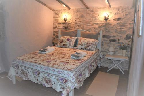 a bedroom with a bed and a stone wall at Casas de Xisto in Mogadouro