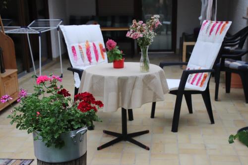 a table and two chairs with flowers on it at Hostel Bad Salzig in Boppard