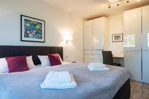 1 dormitorio con 1 cama grande y toallas. en Terrassenwohnung "Haffparadies" - Oase am Haff, en Garz