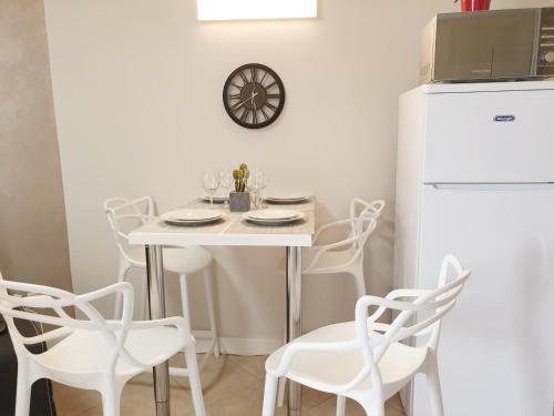 a white dining room with a white table and chairs at GK Apartment Delight in Bat Yam