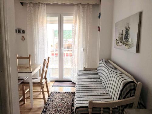 a room with a bed and a table and a window at Traditional penthouse with mountain view in Grevena