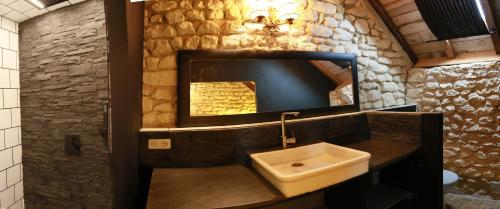 ein Badezimmer mit Waschbecken und Spiegel in der Unterkunft La Grange du Moulin in Noyers-sur-Cher