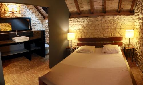 ein Schlafzimmer mit einem Bett, einem Waschbecken und einem Klavier in der Unterkunft La Grange du Moulin in Noyers-sur-Cher