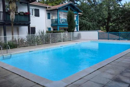 a large blue swimming pool in front of a house at Eric's Appartement -Charmant T2 - in Cambo-les-Bains