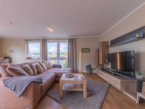 un soggiorno con un grande divano e una TV a schermo piatto di Modernes Apartment "Stadtblick" a Waren