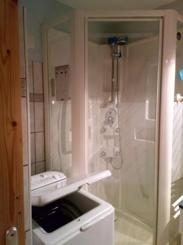 La salle de bains blanche est pourvue d'une douche et d'un lavabo. dans l'établissement HSL, à Valmorel