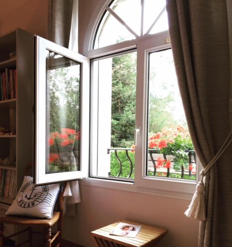 two windows in a room with a book shelf at Chambres La Guignardais in Lamballe