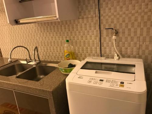 a kitchen with a sink and a washing machine at Arsyad Homestay Changlun in Changlun