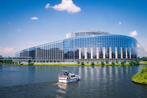 a boat in the water in front of a building at La chambre aux hirondelles in Ittenheim