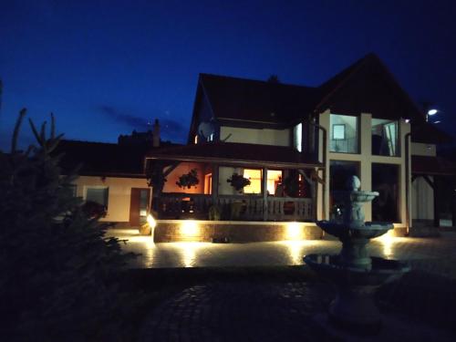 a house with a fire hydrant in front of it at night at András penzión in Krásnohorské Podhradie