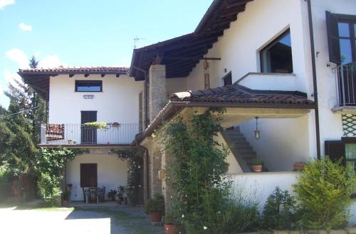 a large white house with a porch and a balcony at MAMOTA B&B in Vesime