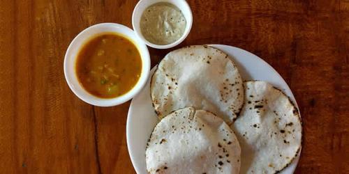 un piatto di cibo con una ciotola di salsa per immersione di SilverShine Homestay a Chikmagalūr