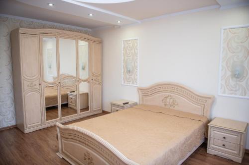 ein Schlafzimmer mit einem Bett und einem großen Spiegel in der Unterkunft Затишна оселя in Mischhirja