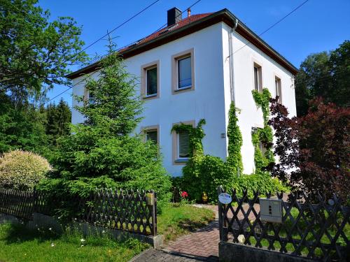 una casa blanca con una valla delante en Ferienwohnung am Wald, en Tharandt