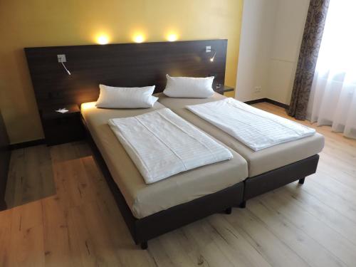 1 dormitorio con 1 cama grande y cabecero grande en Apart-Hotel Wiesbaden en Wiesbaden