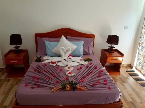 a bed with a bunch of flowers on it at Mirella Villa Holiday Apartment in Praslin