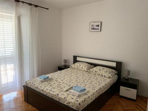 a bedroom with a bed with two towels on it at Guest House Ruža in Sobra