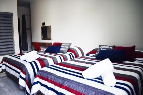 a group of three beds in a room at En el Centro 1 Hermoso Lof't Familiar AC WiFi 300 mbps in Aguascalientes