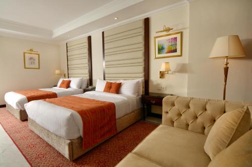 伊斯蘭堡的住宿－Islamabad Regalia Hotel，酒店客房,设有两张床和一张沙发