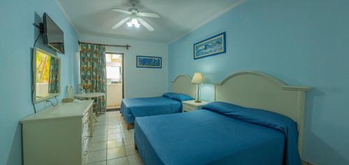 two beds in a room with blue walls at Hotel Costa Brava in Manzanillo