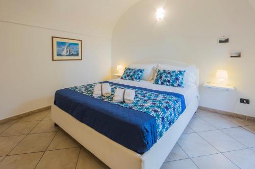 ソレントにあるMaison del Mare Sorrento.のベッドルーム1室(大型ベッド1台、青いシーツ、枕付)