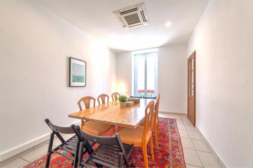 une salle à manger avec une table et des chaises sur un tapis dans l'établissement Lovely large familial apartment in central Nice, ten minutes walk to the beach!, à Nice