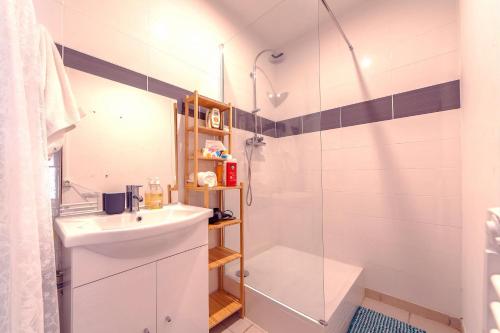 une salle de bain blanche avec un lavabo et une douche dans l'établissement Lovely large familial apartment in central Nice, ten minutes walk to the beach!, à Nice