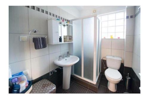 un baño con inodoro y lavabo en Seaside Family House, en Nikiana