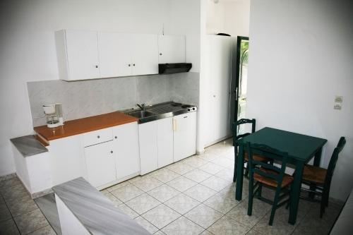 a kitchen with a table and a green table and chairs at Zeus Hotel in Iraion