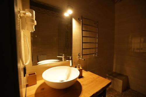 a bathroom with a large white bowl sink on a wooden counter at SPA HOTEL Gora in Bukovel