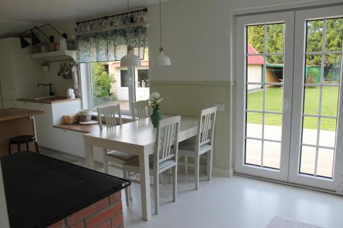 a kitchen with a white table and chairs and a window at Villa Orissaare in Orissaare