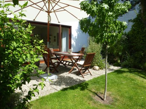 a table and chairs under an umbrella in a yard at Kleines Refugium in Bad Sachsa